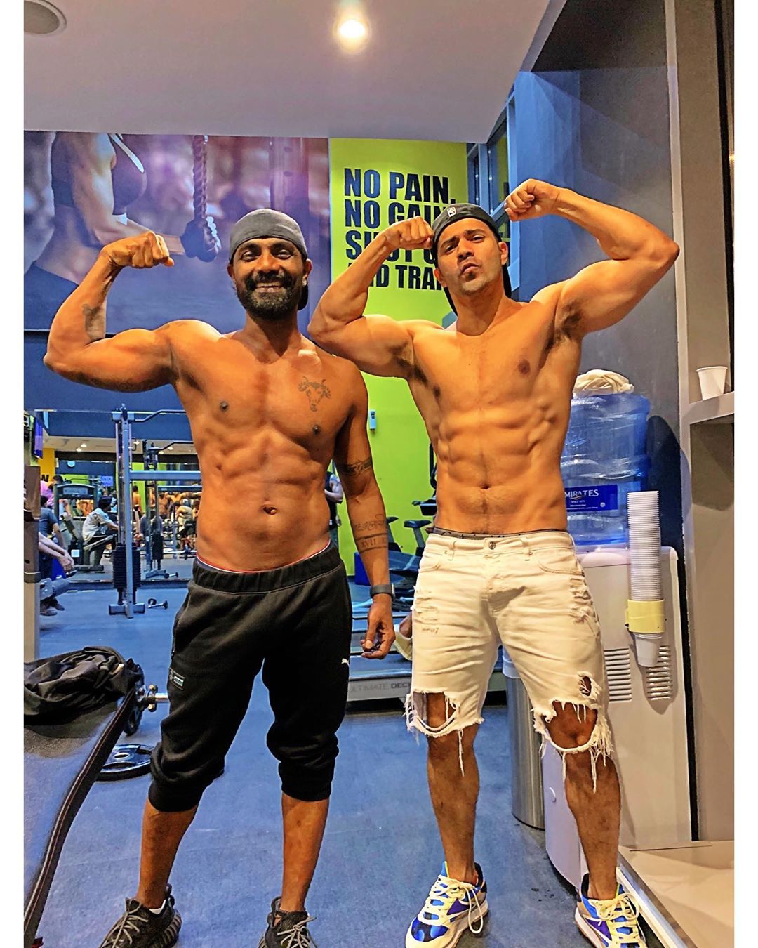 fitness freak varun dhawan showing his biceps with choreographer remo dsouga