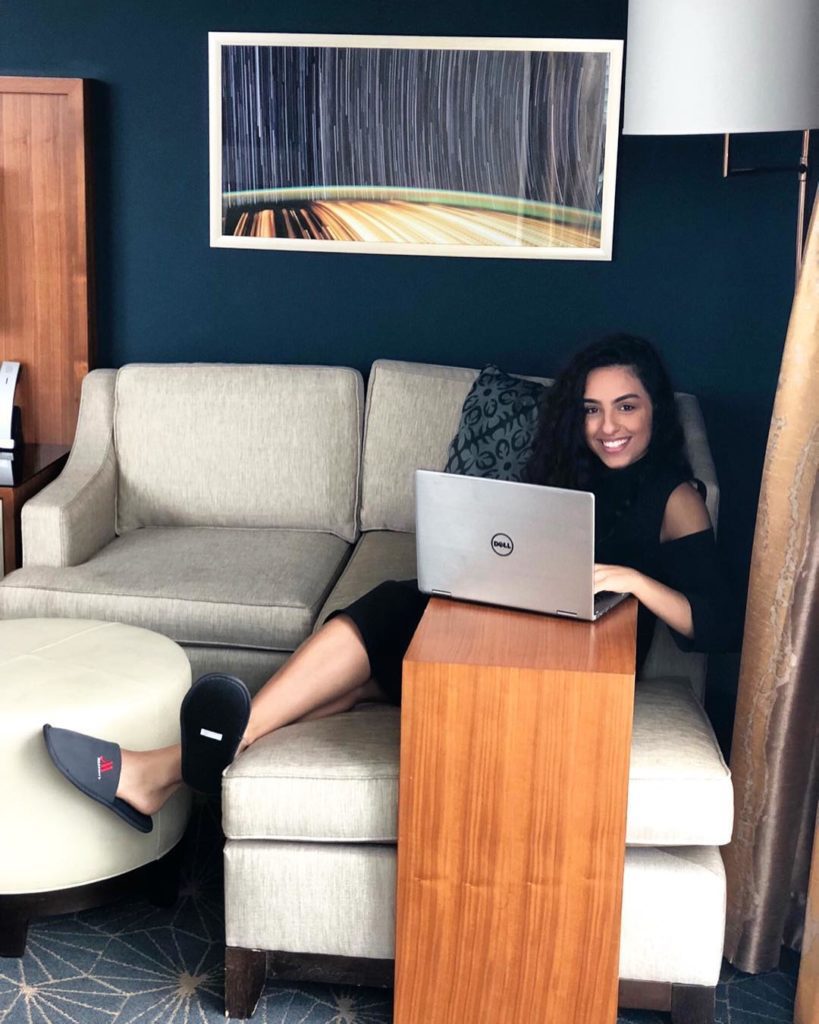 ashley zahabian on sofa working on her laptop public speaker age height biogrpahyw ik